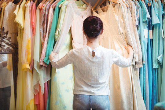 Woman selecting a clothes from hanger