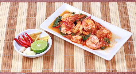 Fried spicy basil with shrimp and side dish as halve green lemon ,red chili and garlic are popular Thai food. 