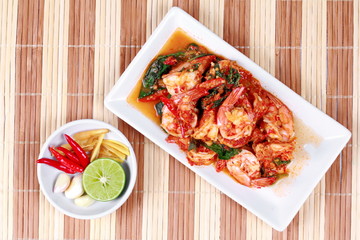 Fried spicy basil with shrimp and side dish as halve green lemon ,red chili and garlic are popular Thai food. 