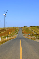 Asphalt road and wind turbines