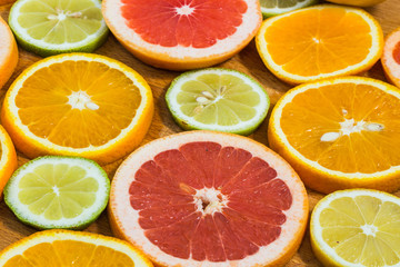Fototapeta na wymiar Citrus fruit background with sliced f oranges lemons lime tanger