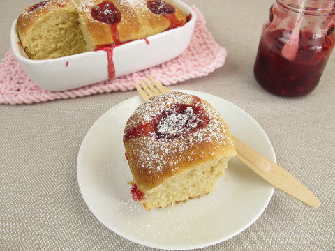 Selbst gebackene Buchteln mit Preiselbeermarmelade und Puderzucker