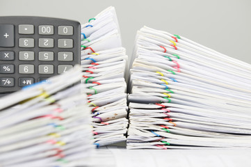 Pile overload document and calculator have blur paperwork as foreground