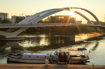 Ship at the shore of the Rhone river, in front of bridge ’Pont Raymond Barre’, Lyon, France.