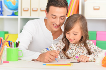 Father and daughter painting at home