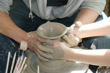 potter teaches the student the art of clay pottery