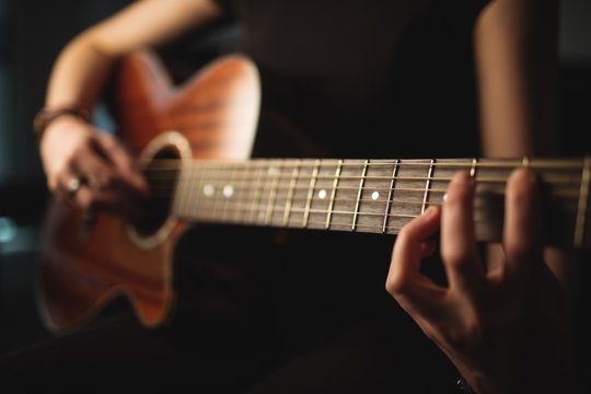 Close up of woman playing guitar