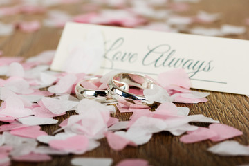 Naklejka na ściany i meble wedding rings on a wooden background with confetti