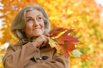Beautiful middle-aged woman on the background of autumn leaves