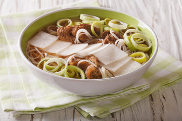 Korean soup with beef, rice noodles, leeks and daikon close up. horizontal
