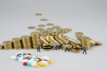 Stack of gold coin with miniature people and blur medicine