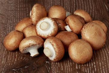 the raw royal mushrooms on a wooden table