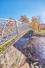 across the river bridge in the autumn park