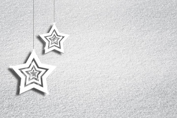 Fototapeta na wymiar Abstract snow texture background with illustrated Christmas and New Year Holiday decoration star shapes hanging on string. Xmas decortation background with copy space background.