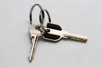 a bunch of two metal keys on a homogeneous gray background