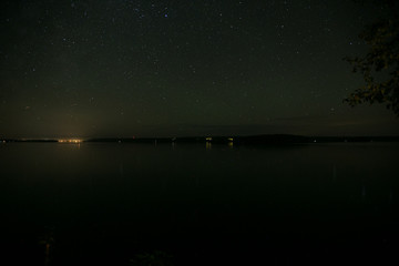 Long exposure of the stars lake and trees