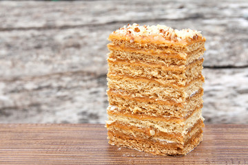 A piece of cake outdoors. Old gray wooden background. Close-up. Selective focus.