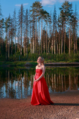 Fototapeta premium Portrait of beautiful girl in red dress on sand beach nature