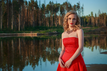 Portrait of beautiful girl in red dress in nature