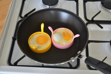 Two eggs frying in a pan.