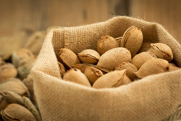 Almonds on brown wooden background