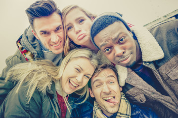 Best friends taking selfie outdoor on autumn winter clothes - Happy youth concept with multiracial...