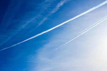 Cloudscape with trail of jet plane on blue sky. Natural background.