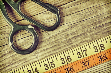sartorial meter and scissors on the old wooden background