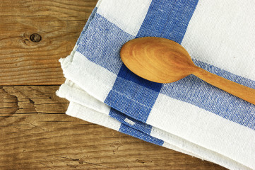 wooden spoon and dishcloth on old wooden table