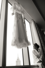 A view from afar on a  bride sitting on a windowsill of huge win