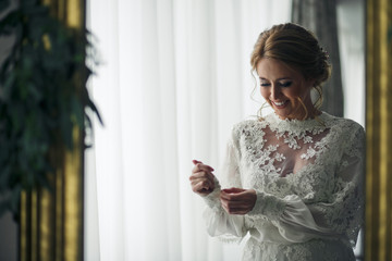 Bride looks fabulous adjusting long sleeves on a wedding dress