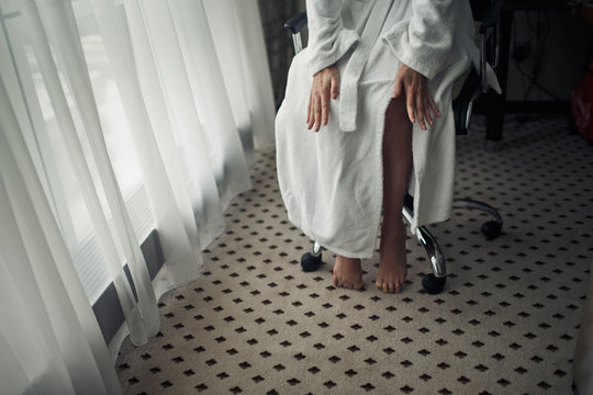 View on pretty legs under a white bathrobe