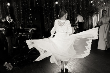 Stunning bride whirls her dress dancing with guests