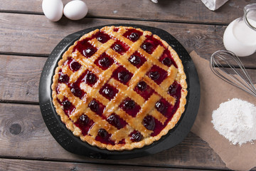 Homemade traditional sweet cherry  tart pie with  wooden table background.