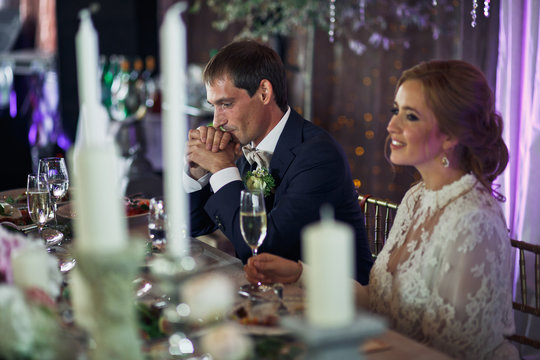 Groom sits thoughtful at the dinner table while bride drinks cha