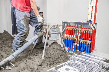 Employee performs sand and cement screed floor. Sand and cement floor screed
