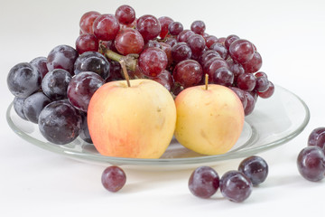 apple and grape on dish glass