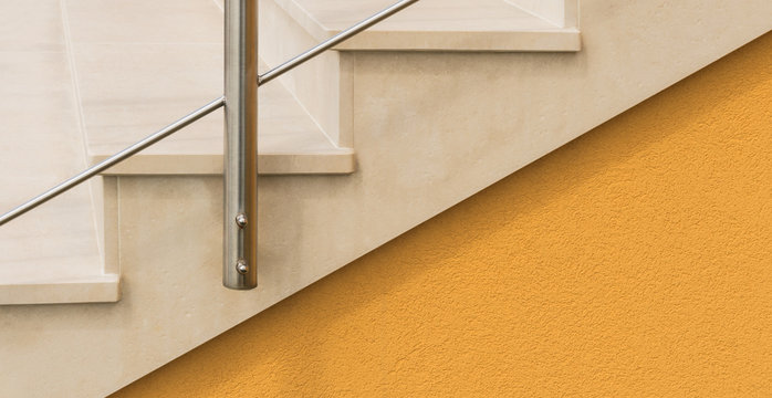 Befestigung Edelstahltreppengel&auml;nder an einer hellen Natursteintreppe als closeup - Attaching a stainless steel banister at a bright stone staircase as closeup