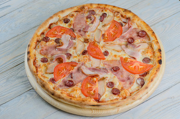 pizza with bacon, ham, salami and vegetables