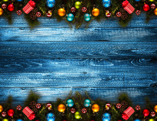 2017 Happy New Year seasonal background with real wood green pine, colorful Christmas baubles, gift boxe and other seasonal stuff over an old wooden aged background