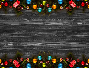 2017 Happy New Year seasonal background with real wood green pine, colorful Christmas baubles, gift boxe and other seasonal stuff over an old wooden aged background