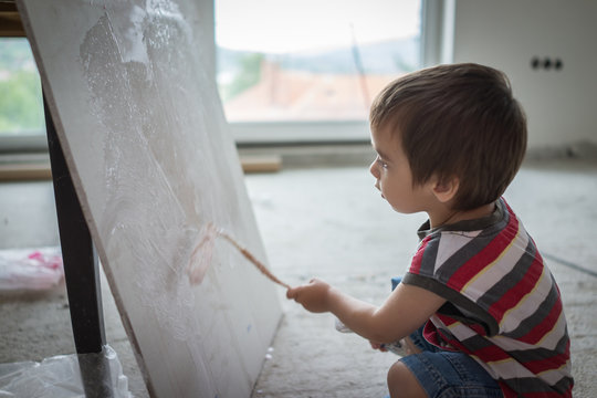 Little cute boy painting on a wall
