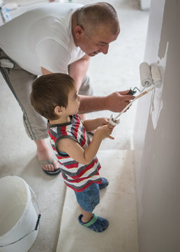 Little cute boy painting on a wall