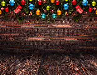 2017 Happy New Year seasonal background with real wood green pine, colorful Christmas baubles, gift boxe and other seasonal stuff over an old wooden aged background