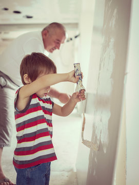 Little cute boy painting on a wall