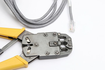 Obraz premium Crimping tool and network cable on white background