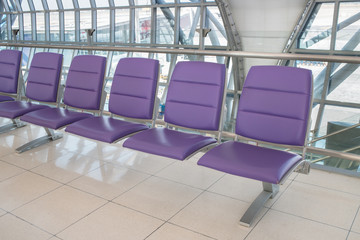 Airport terminal interior with rows of empty seats, city view an