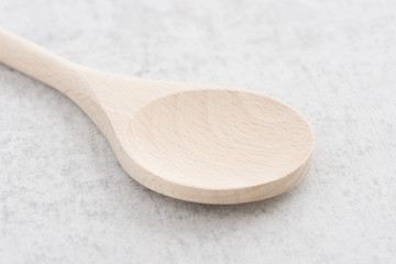 Wooden spoon on stone table. Traditional cooking equipment. Wood kitchenware object used for food,...