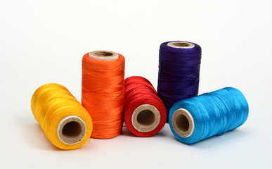 Spools of colorful silk threads on white background