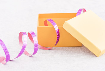 Gift wrapping for a holiday celebration, birthday or surprise party. Preparation of present with ribbon, box and decoration on table. Festive package material.